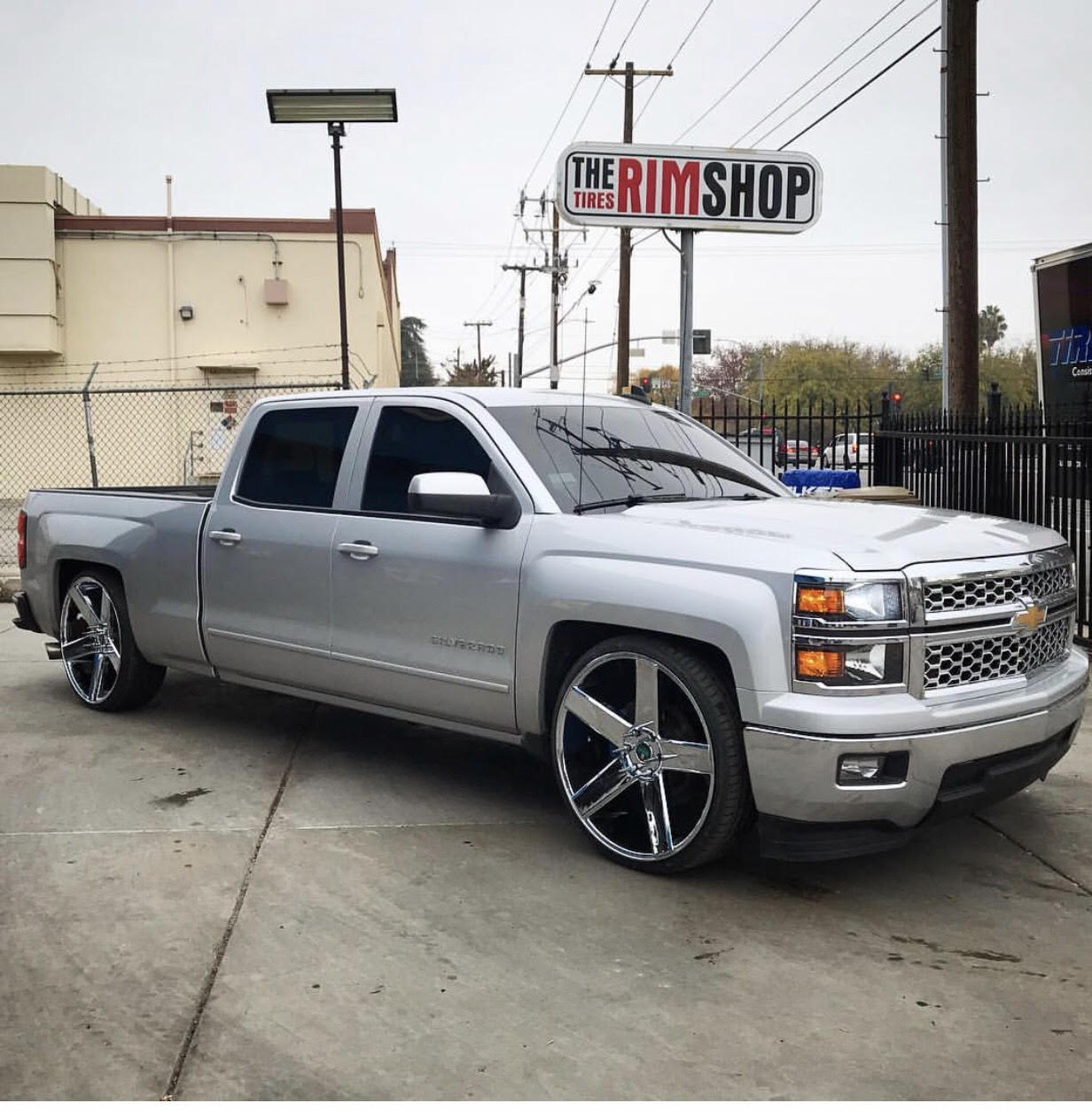 Lowered silver Chevy Silverado with custom wheels