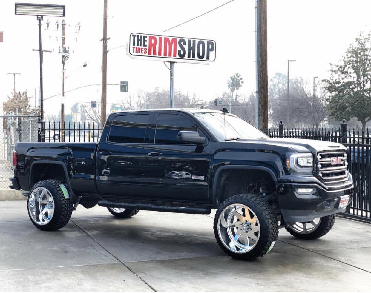 Black GMC truck with aftermarket wheels