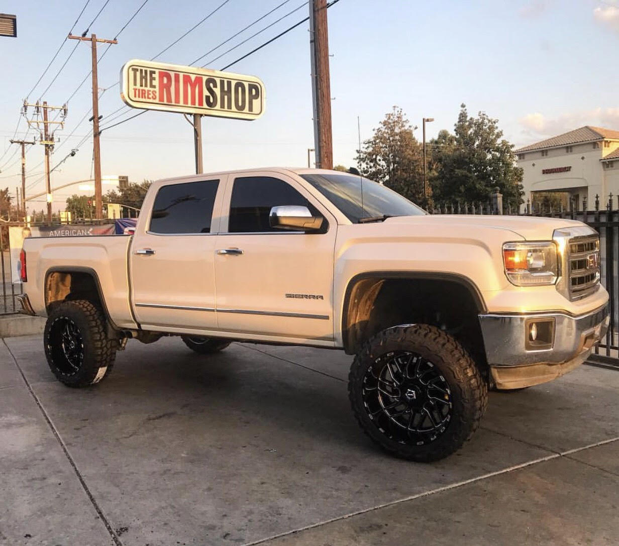 White GMC Sierra truck with custom wheels installed
